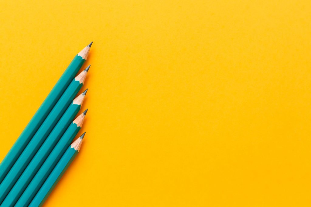 lápis verde em fundo amarelo